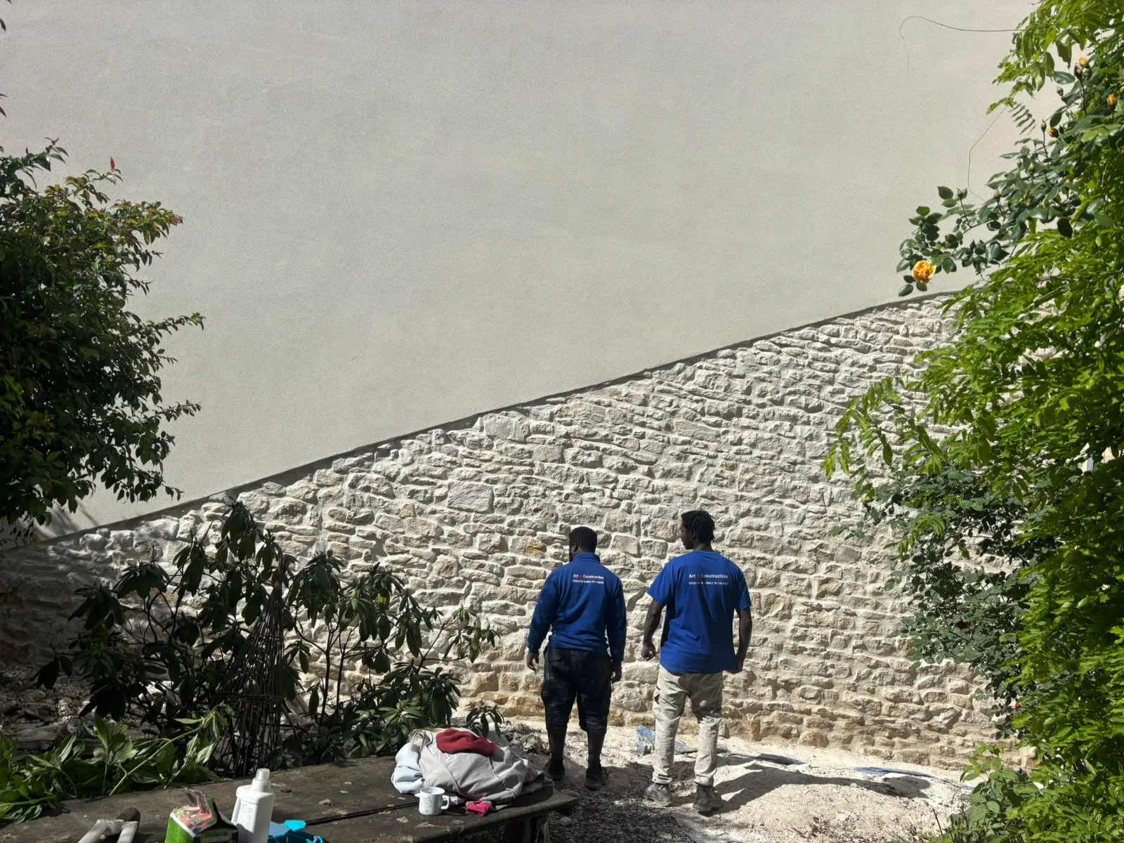 Pignon ravalé à Nevers : mur en pierre rejointoyé en partie basse, enduit à la chaux au-dessus, deux compagnons d’Art et Construction devant
